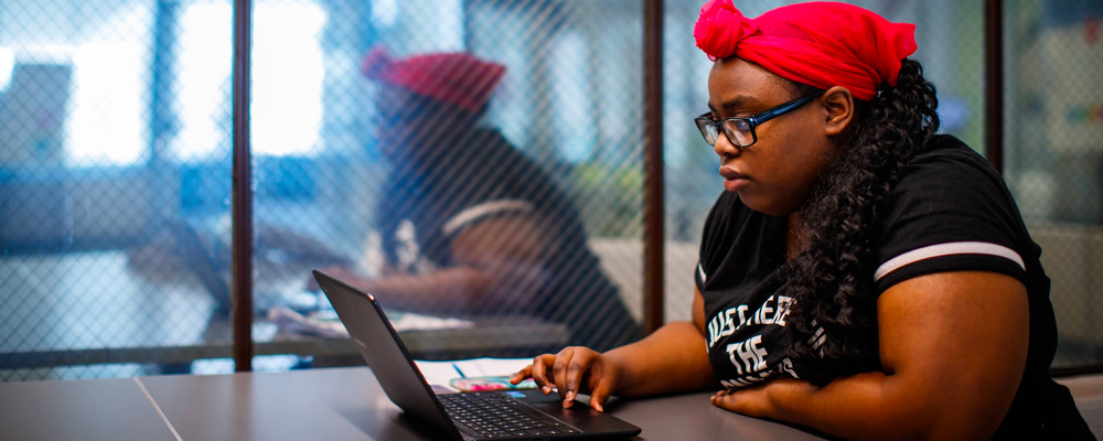 A photo of a student at her laptop.