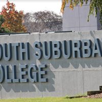 A picture of a sign on the Main Campus in autumn that says, "South Suburban College".